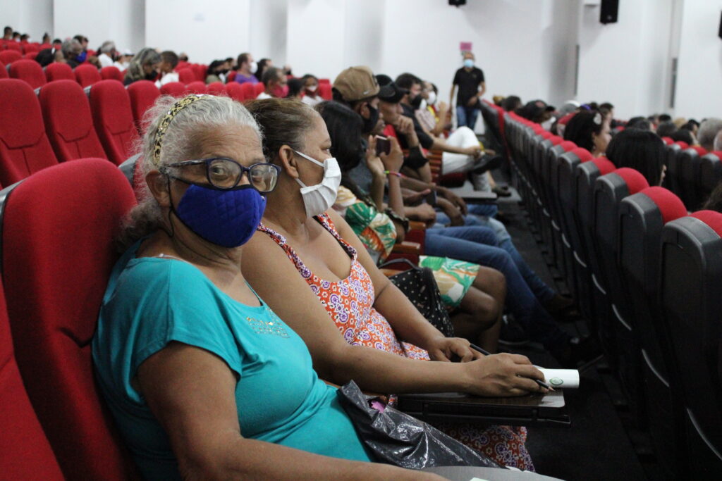 Pessoas sentadas em cadeiras em um auditório